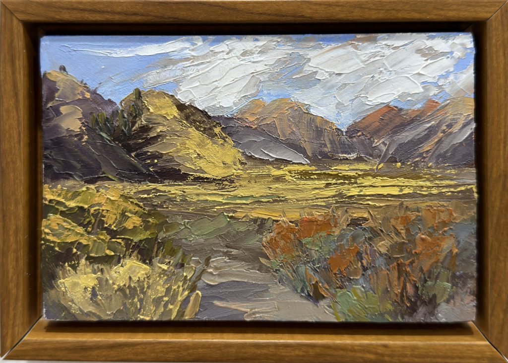 Framed plein air painting of Mono Lake in fall, with golden foliage, mountains, and a textured cloudy sky.